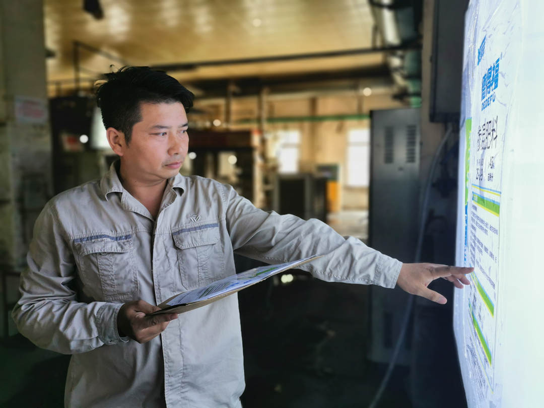 张红贵正在核对版样.jpg 张红贵正在核对版样.jpg